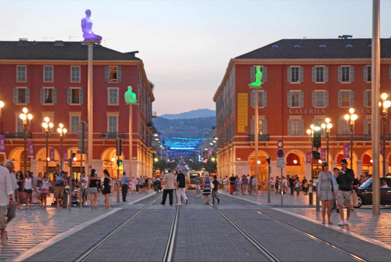Place Masséna au crépuscule, tramway et façades rouges